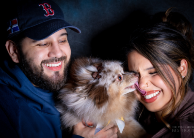 Boston MA couple enjoying a sweet kiss by their Pomeranian pup
